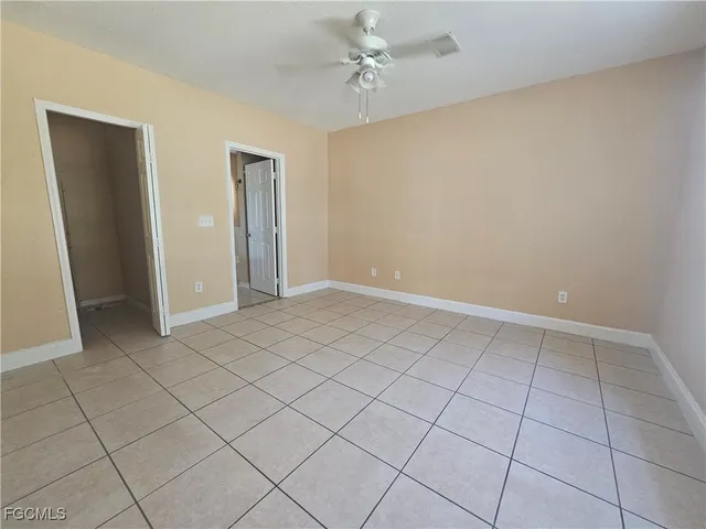 an empty room with windows and fan