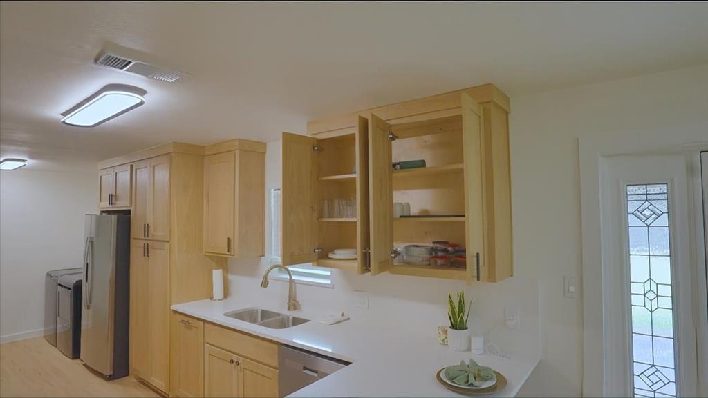 3509 West Sublett Road Arlington, TX 76017 - Photo 16 of 39 Light wood-finish cabinetry, stainless steel appliances, and a double basin sink