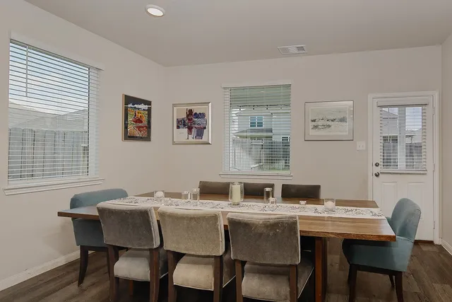 a kitchen with granite countertop a dining table chairs and a wooden floor