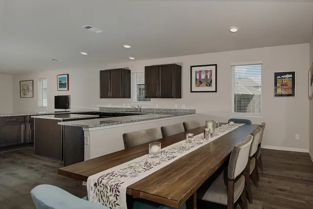 a living room with stainless steel appliances kitchen island granite countertop furniture and wooden floor