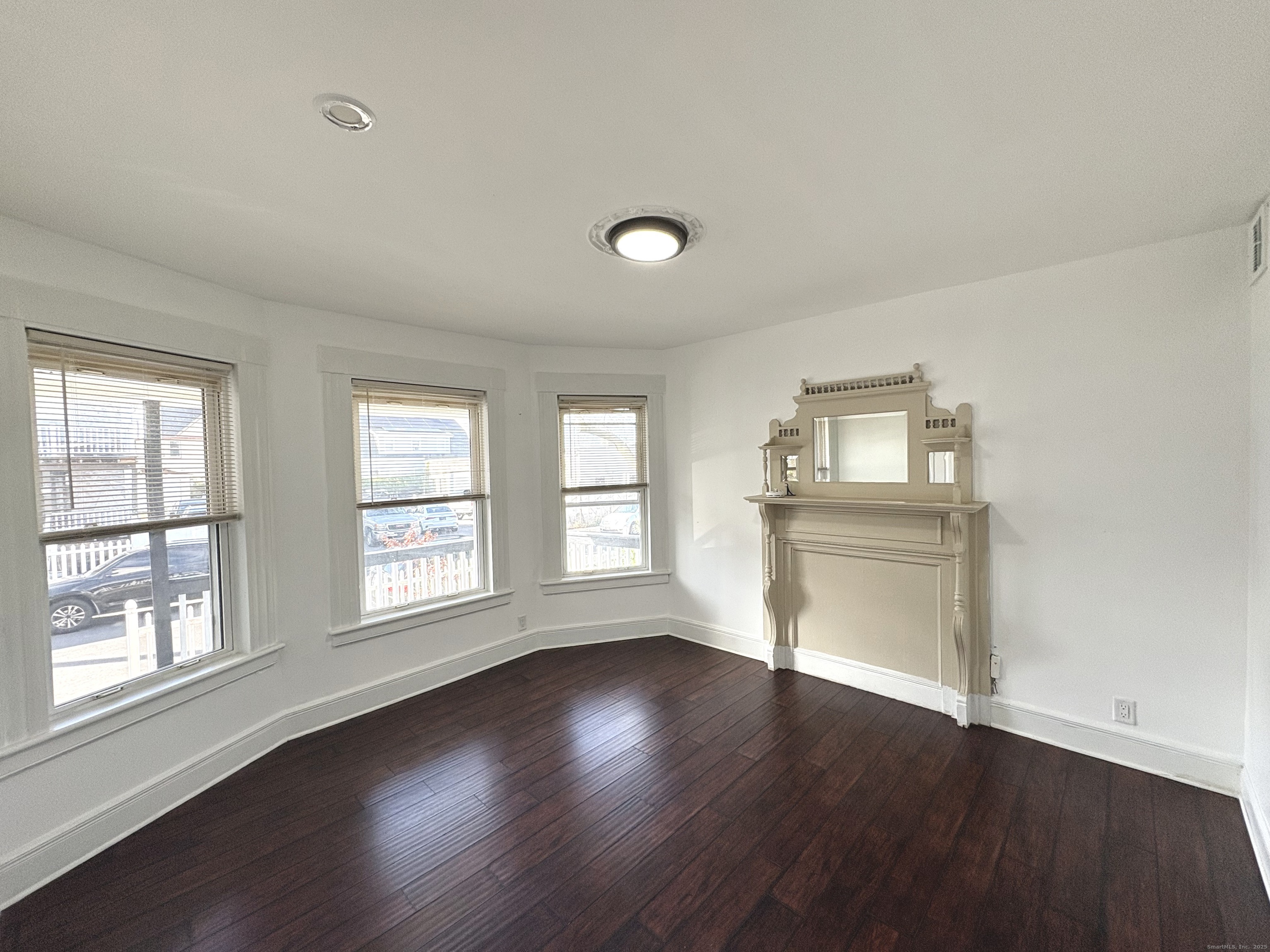 25 Deforest Avenue Bridgeport, CT 06607 - Photo 2 of 11 a view of an empty room with wooden floor and a window
