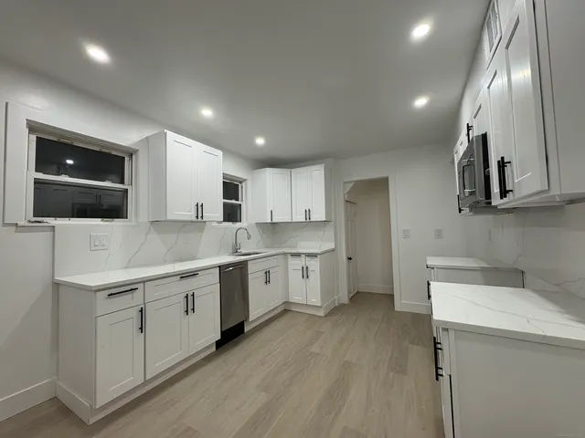 a kitchen with a sink stainless steel appliances and cabinets