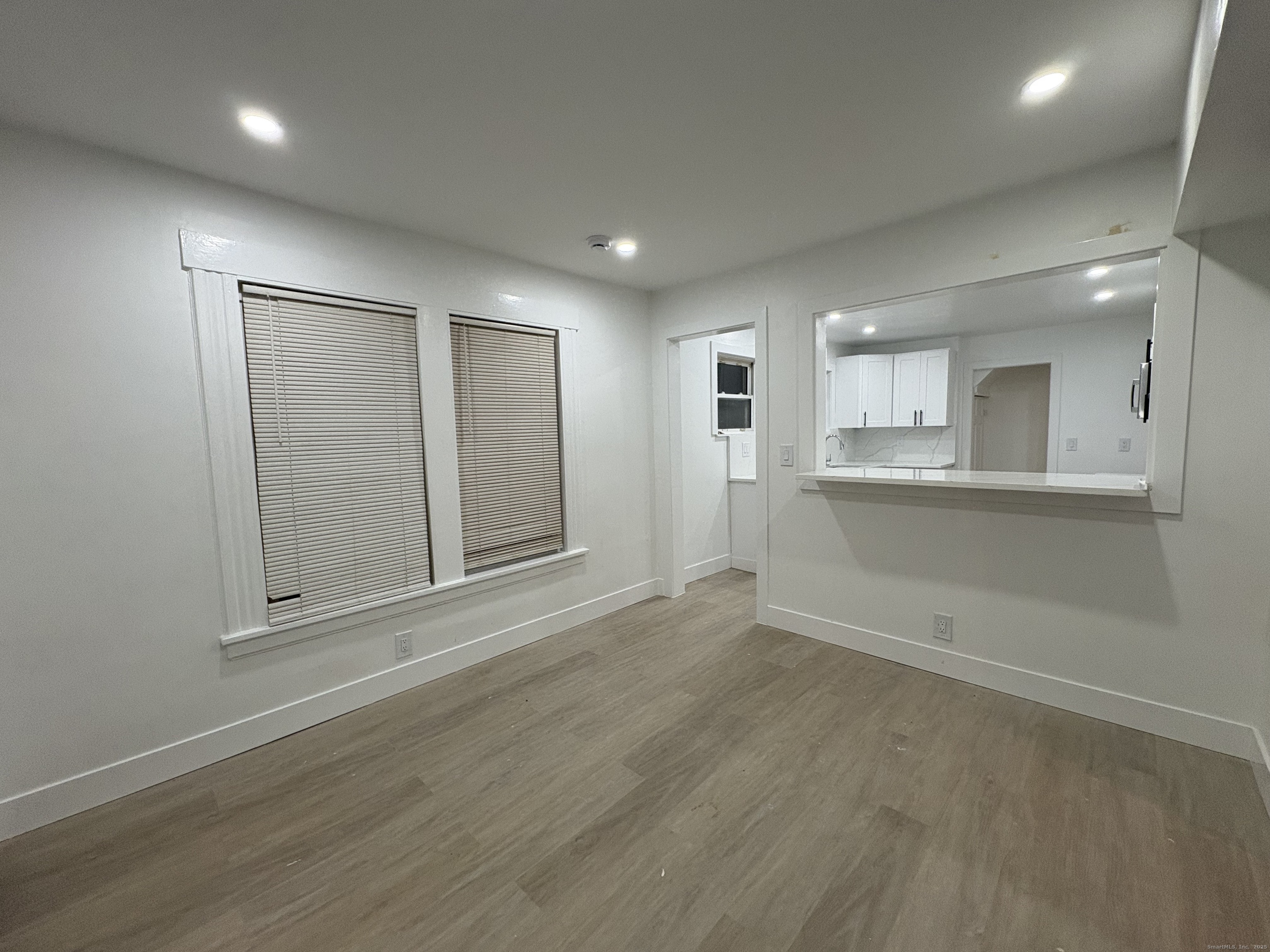 25 Deforest Avenue Bridgeport, CT 06607 - Photo 7 of 11 an empty room with wooden floor and windows
