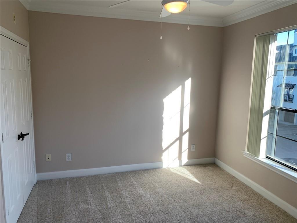 7701 Rialto Boulevard, Unit 1222 Austin, TX 78735 - Photo 10 of 14 Well-lit room featuring soft carpeting and crown molding, ready for your personal touch.
