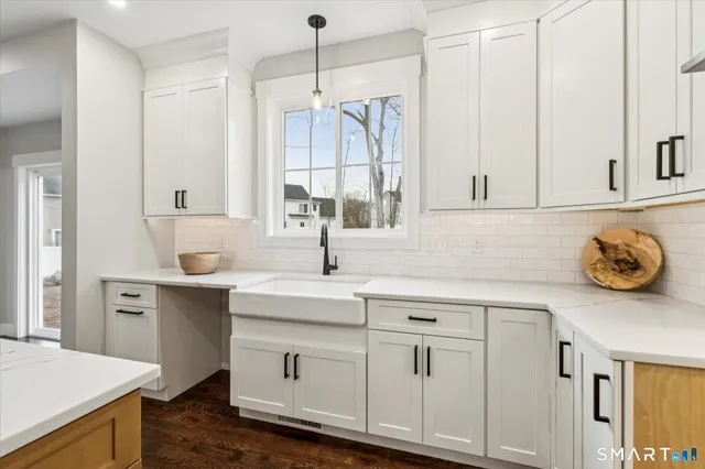 a large white kitchen with a large window and stainless steel appliances