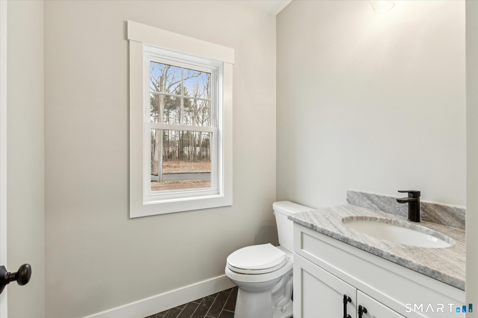 592 Village Street Bristol, CT 06010 - Photo 32 of 38 a bathroom with a granite countertop toilet sink and mirror