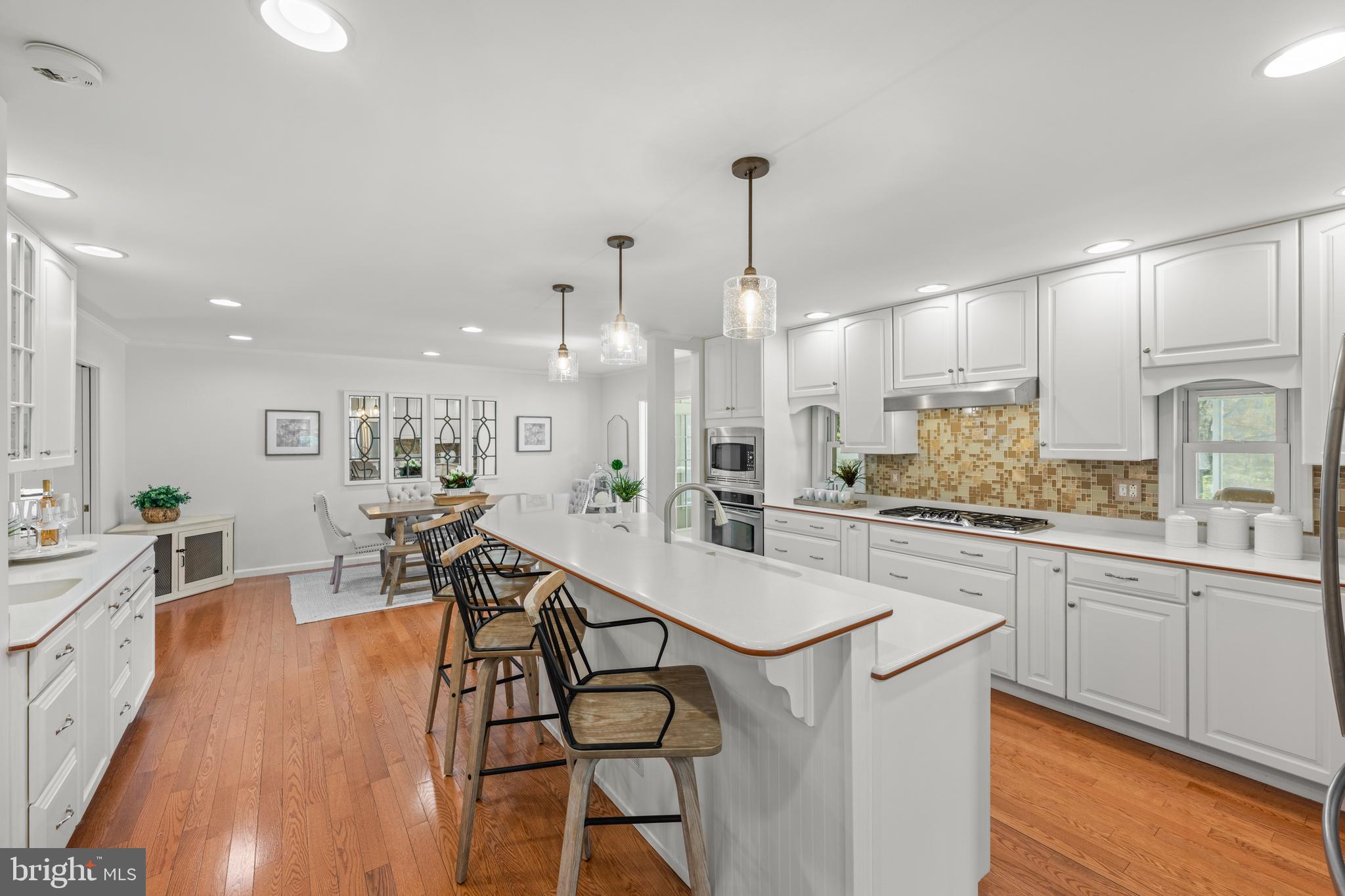 174 Coldstream Drive Berwyn, PA 19312 - Photo 12 of 40 a kitchen with stainless steel appliances granite countertop a sink a stove a refrigerator and island with wooden floor