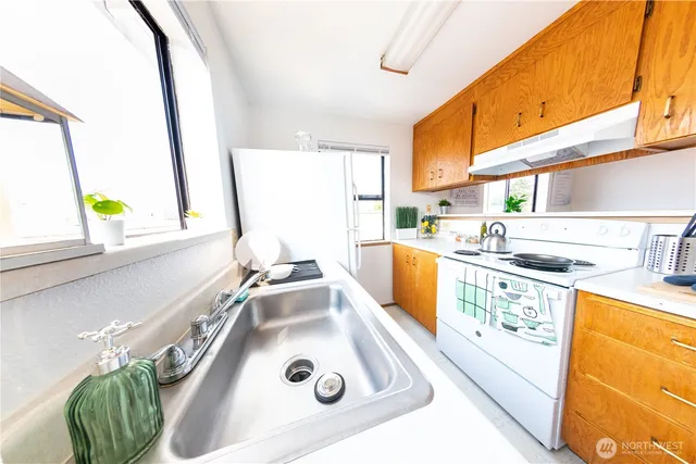a kitchen with a sink a stove and a window