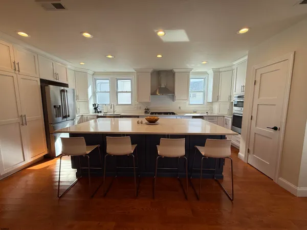 a kitchen with a table chairs refrigerator and cabinets