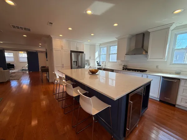 a kitchen with stainless steel appliances granite countertop a table chairs sink refrigerator and cabinets