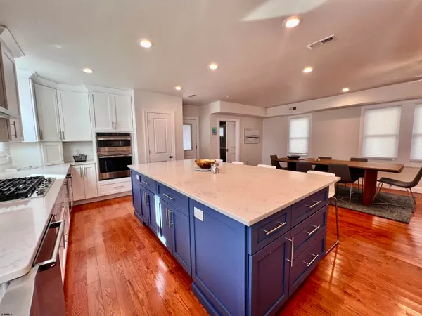 a large kitchen with stainless steel appliances granite countertop a large center island and a sink