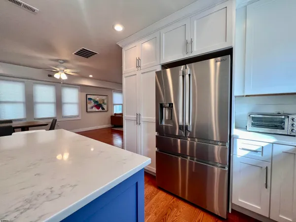 a kitchen with stainless steel appliances wooden floor sink and refrigerator