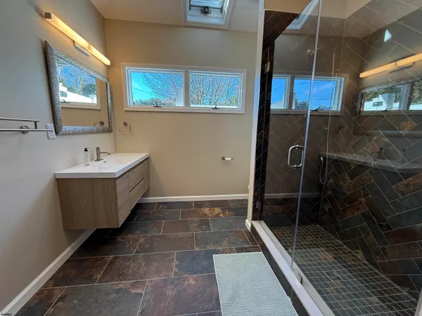 a bathroom with a sink a mirror and shower
