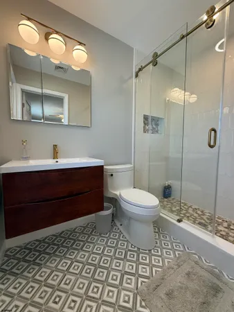 a bathroom with a toilet a sink and mirror