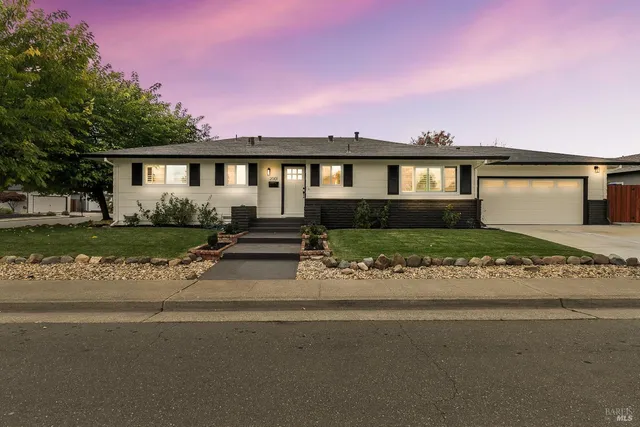 a front view of a house with a garden and yard