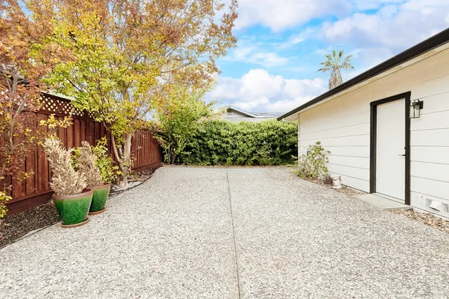 a view of a house with backyard and trees