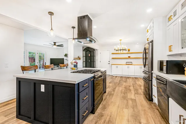 a kitchen with kitchen island granite countertop a sink appliances and cabinets