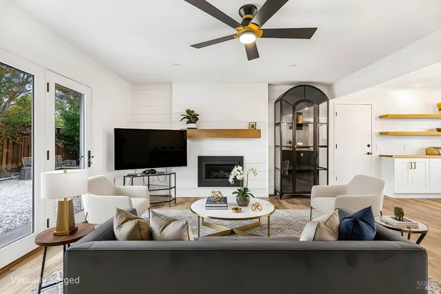 a living room with furniture a flat screen tv and a fireplace