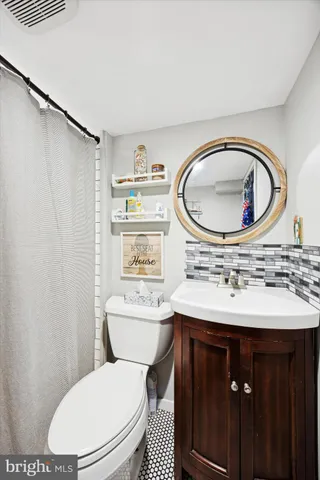 a bathroom with a sink a toilet and a mirror