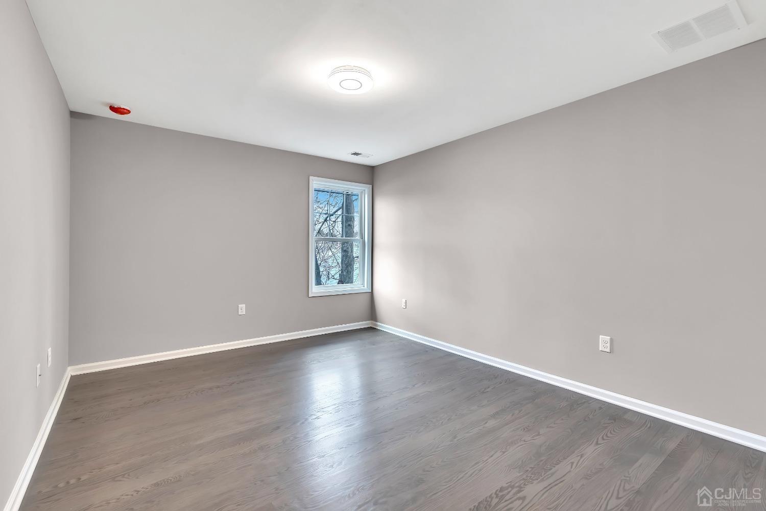 36 Idlewild Road Edison, NJ 08817 - Photo 29 of 34 an empty room with wooden floor and windows