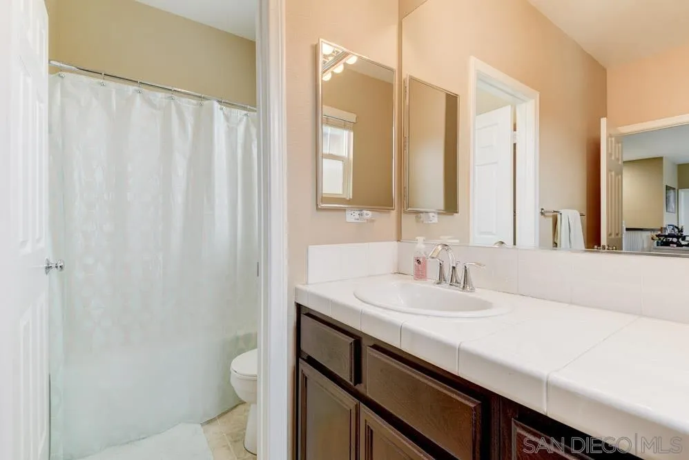 1145 Los Senderos Drive Santee, CA 92071 - Photo 20 of 30 a bathroom with a sink a toilet and a mirror