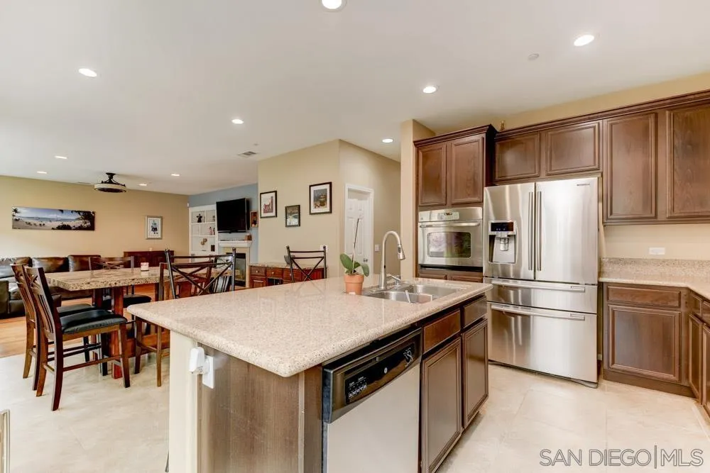 1145 Los Senderos Drive Santee, CA 92071 - Photo 10 of 30 a kitchen with a refrigerator a table and chairs