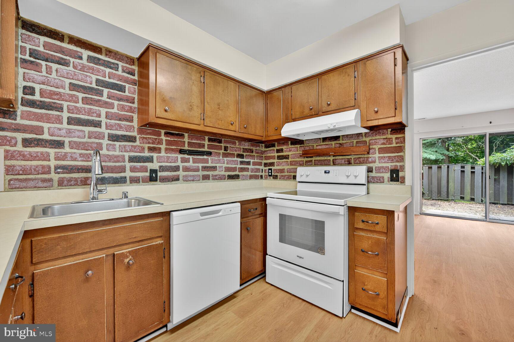1384 Northgate Square Reston, VA 20190 - Photo 4 of 19 a kitchen with stainless steel appliances granite countertop wooden cabinets stove top oven and sink