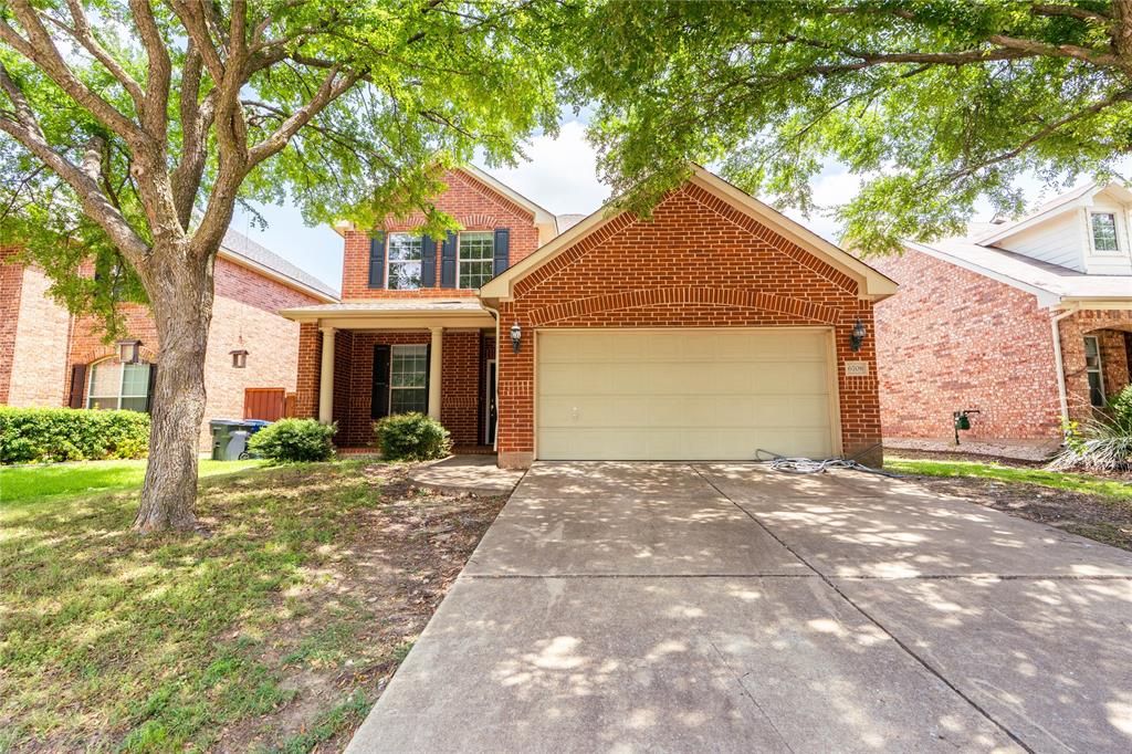 a front view of a house with a yard and potted plants