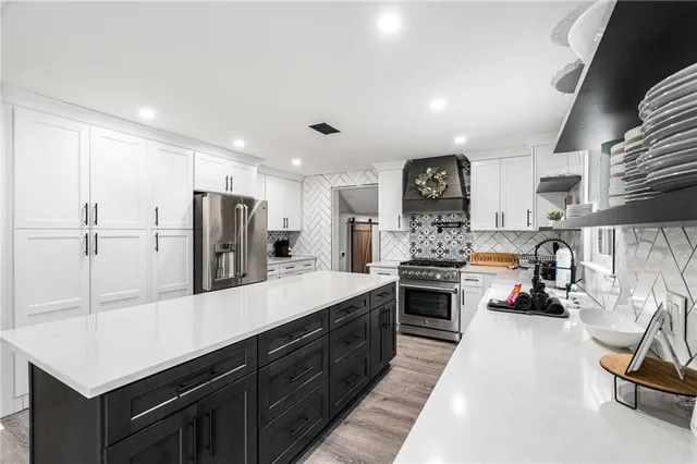 a kitchen with stainless steel appliances a sink stove and refrigerator