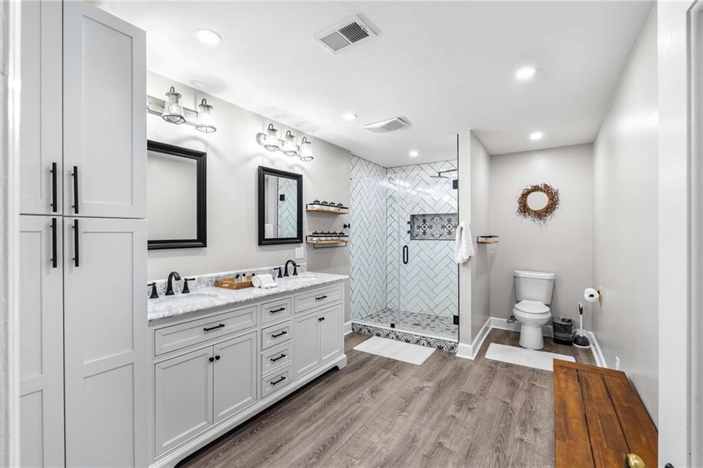 8393 Boardtown Road Ellijay, GA 30540 - Photo 26 of 54 a spacious bathroom with a double vanity sink a mirror and a toilet