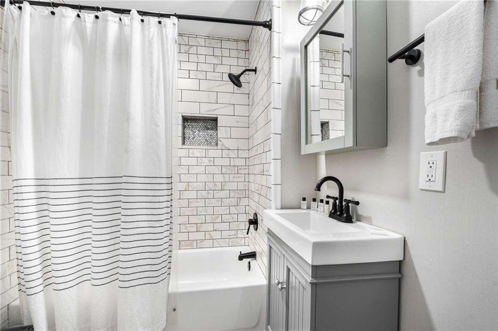 8393 Boardtown Road Ellijay, GA 30540 - Photo 29 of 54 a bathroom with a sink a mirror and a shower curtain