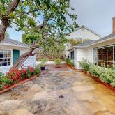 a front view of a house with a yard and flowers