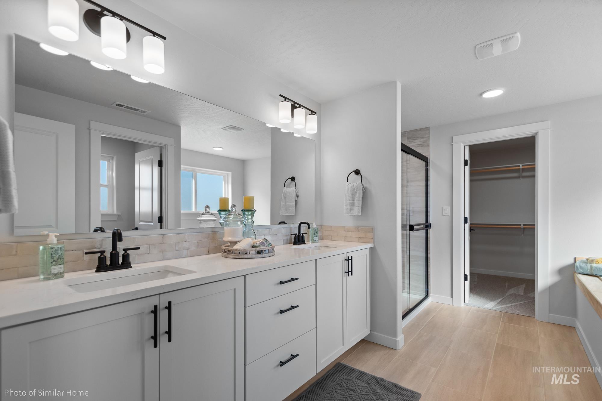 890 Adamite Road Kimberly, ID 83341 - Photo 13 of 16 Bathroom with a stall shower, a walk in closet, double vanity, recessed lighting, and backsplash