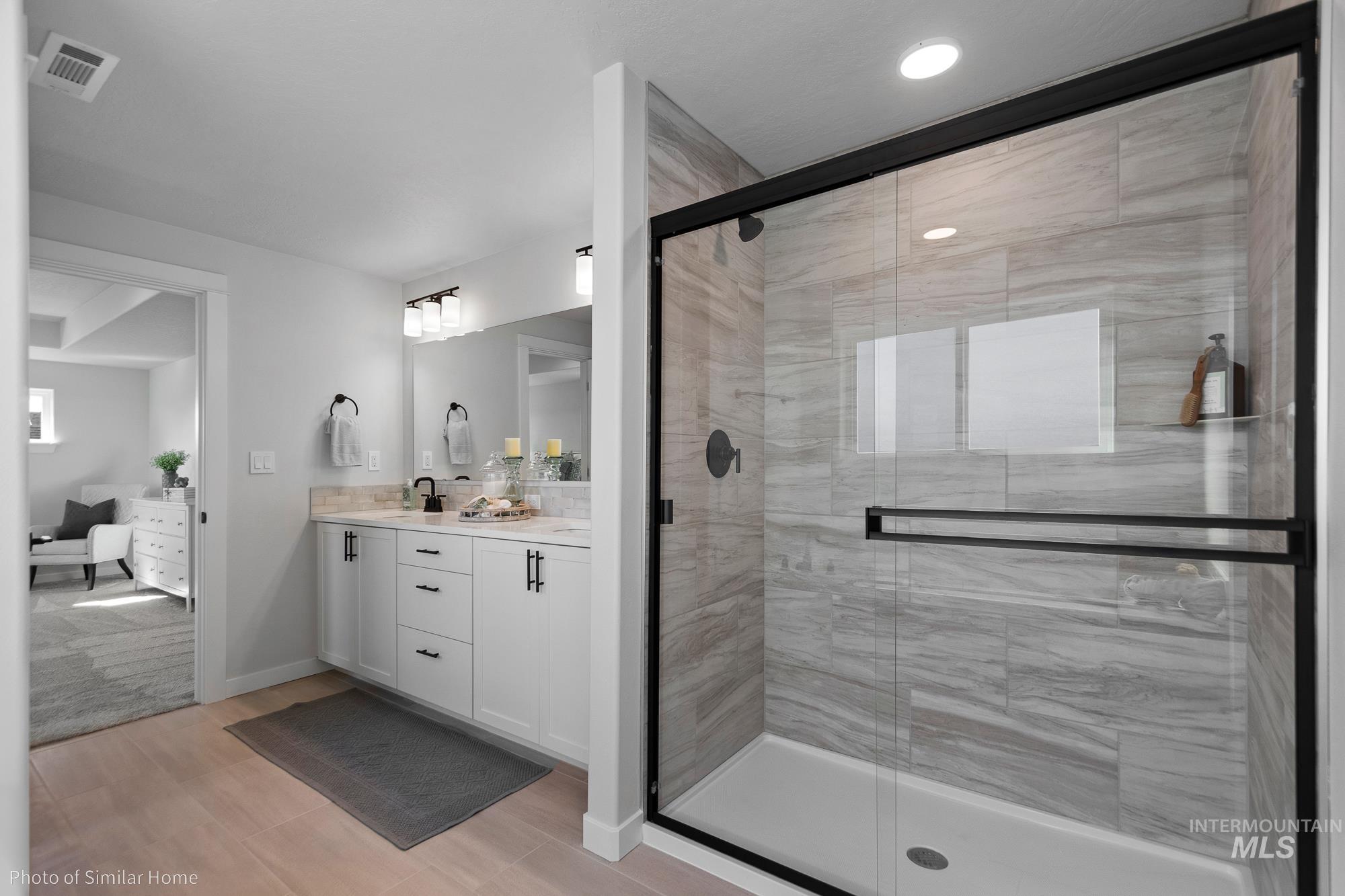 890 Adamite Road Kimberly, ID 83341 - Photo 14 of 16 Full bathroom featuring vanity, a stall shower, connected bathroom, and wood finish floors