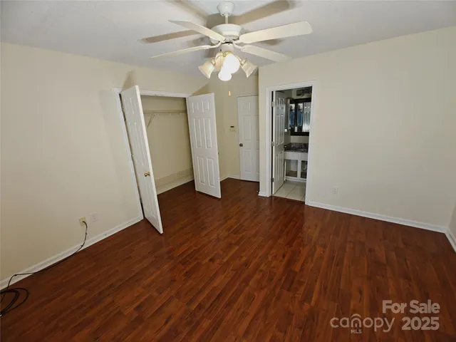 an empty room with wooden floor and a ceiling fan