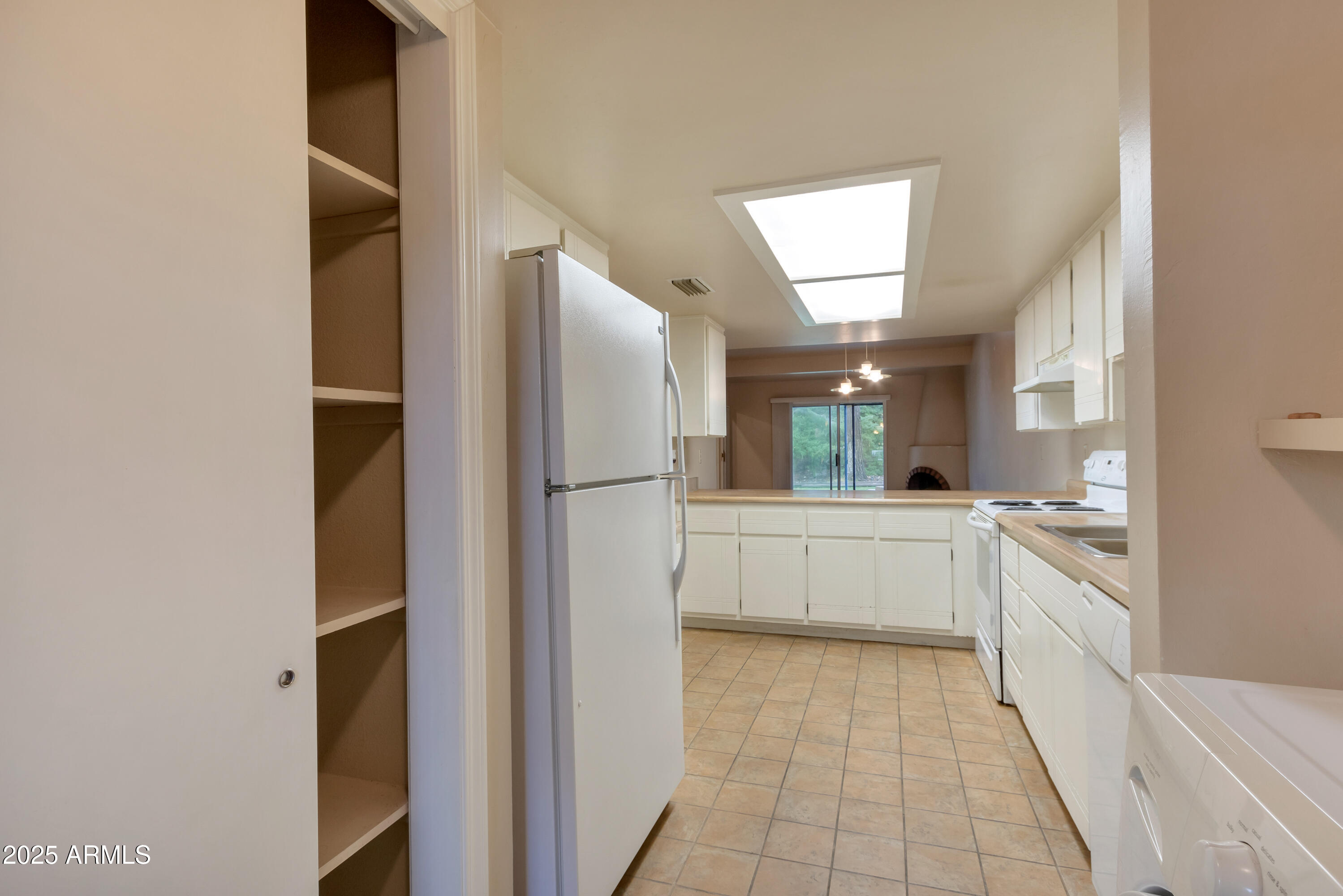 130 Castle Rock Road, Unit 45 Sedona, AZ 86351 - Photo 12 of 38 a kitchen with a refrigerator and white cabinets