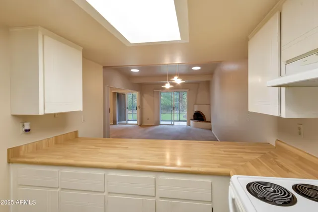 a kitchen with white cabinets and refrigerator