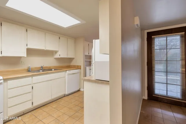 a kitchen with granite countertop white cabinets and white appliances