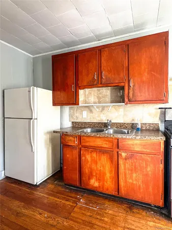 a kitchen with stainless steel appliances granite countertop a refrigerator a stove a sink and dishwasher with wooden cabinets