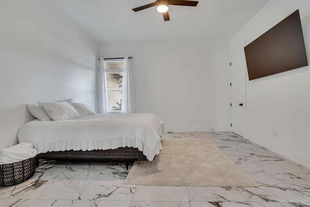 7299 Tom Trail Krum, TX 76249 - Photo 15 of 34 a spacious bedroom with a bed and a flat screen tv