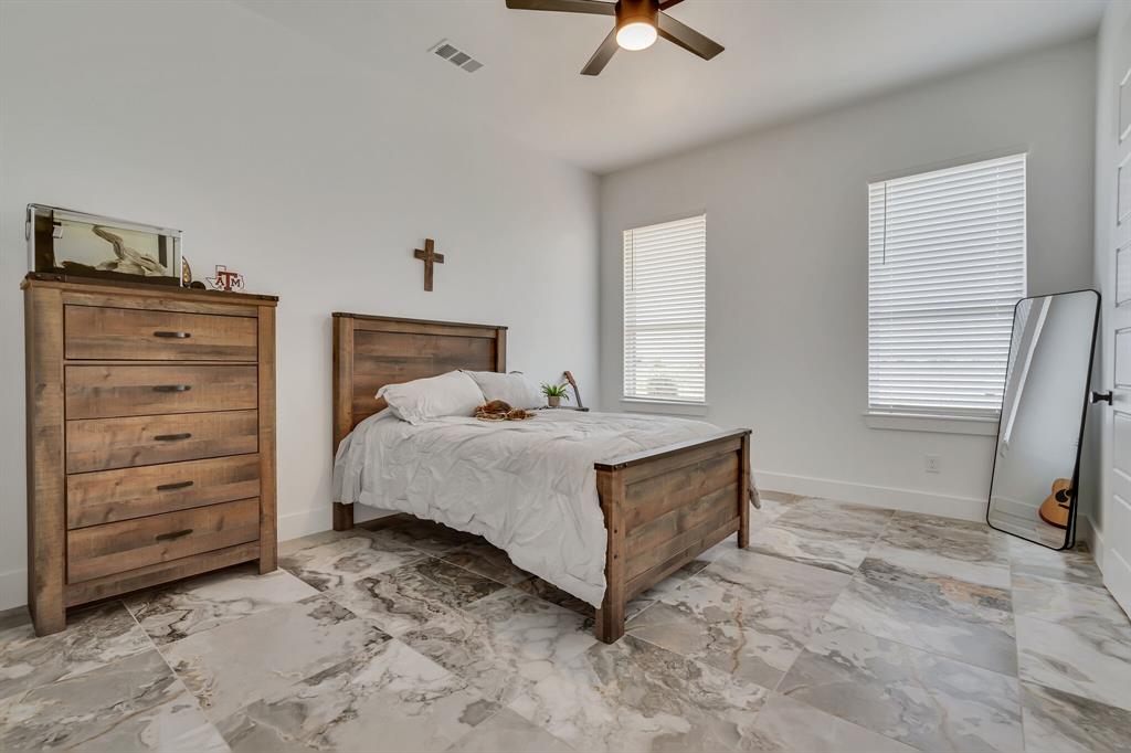 7299 Tom Trail Krum, TX 76249 - Photo 17 of 34 a bedroom with a bed and a dresser