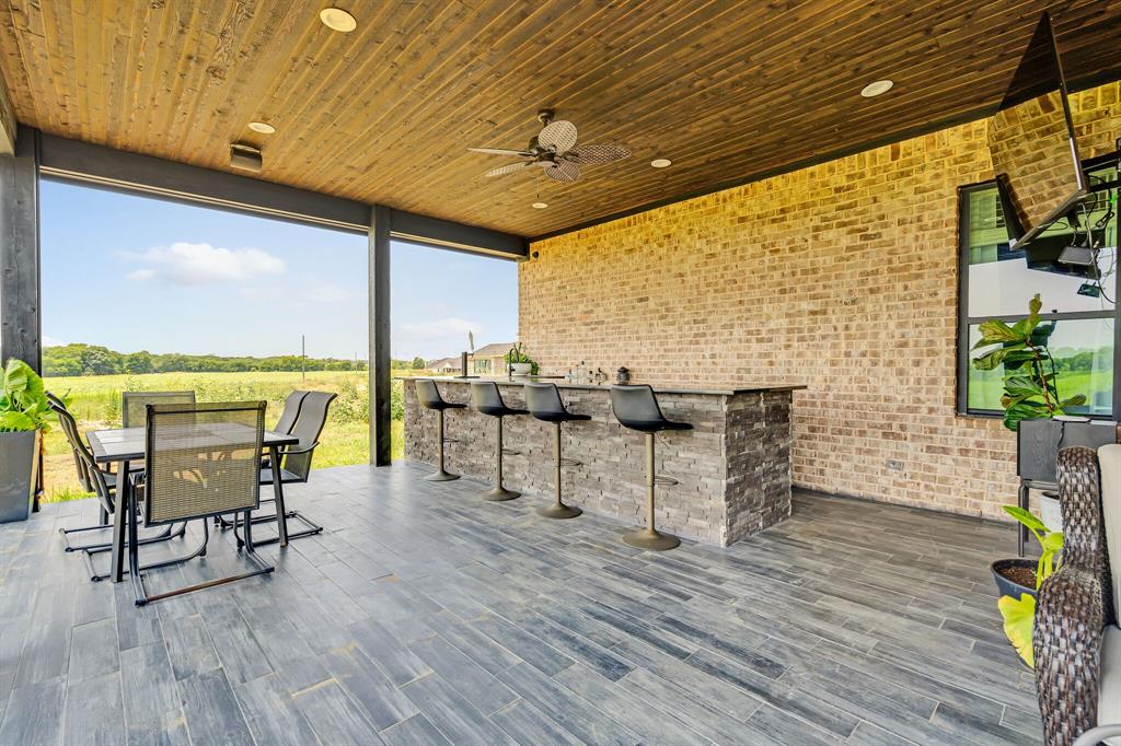 7299 Tom Trail Krum, TX 76249 - Photo 6 of 34 a view of a patio with table and chairs and wooden floor