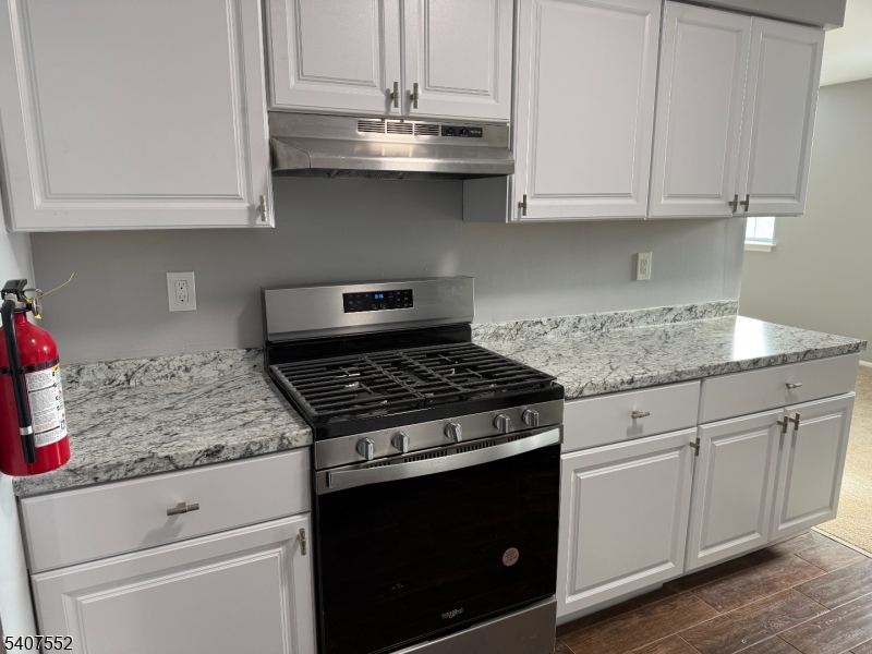103 Park Avenue, Unit 206 Summit, NJ 07901 - Photo 10 of 25 a kitchen with granite countertop white cabinets and a stove