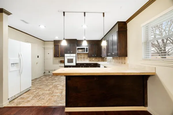 a kitchen with stainless steel appliances granite countertop a sink a stove and a refrigerator