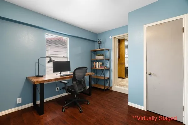 a view of a workspace with furniture and a window