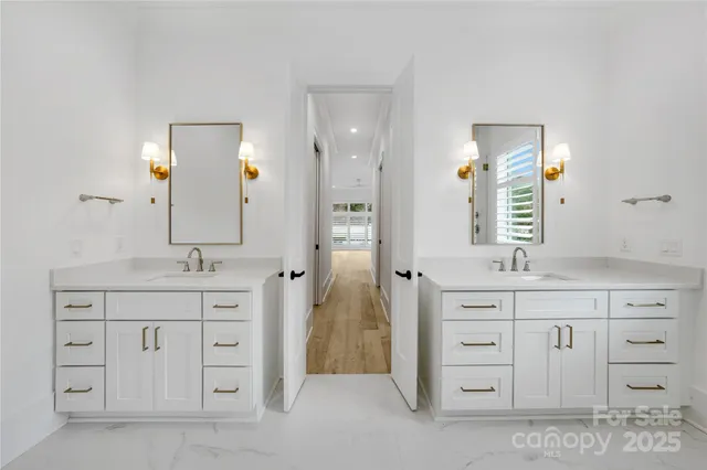 a spacious bathroom with a granite countertop sink double and mirror