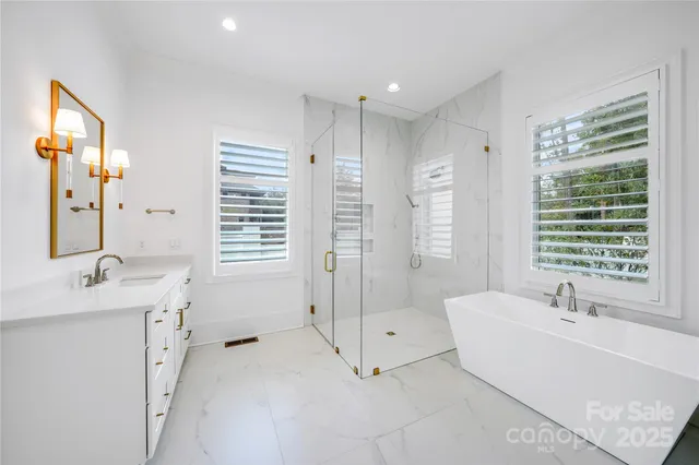 a spacious bathroom with a tub sink and mirror