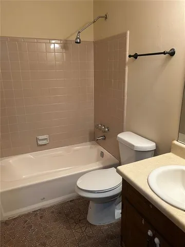a white toilet sitting next to a bath tub and a shower