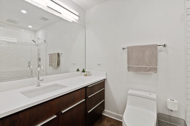 222 South Racine Avenue, Unit 207 Chicago, IL 60607 - Photo 19 of 27 a bathroom with a sink a toilet and mirror