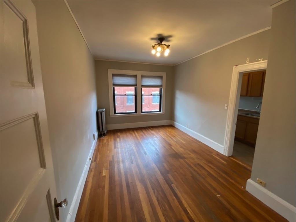 9 Sewall Avenue, Unit 312 Brookline, MA 02446 - Photo 5 of 9 wooden floor in an empty room with a window